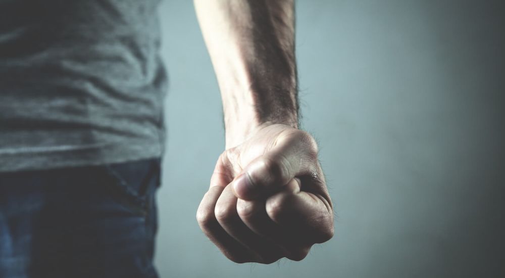 man with balled up fist in anger